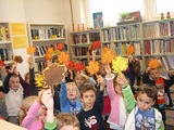 Dzieci w trakcie zabawy prezentują swoje jesienne liście