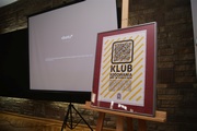 Plakat klubu, w tle ekran systemu UBUNTU
