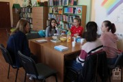 	młodzież i moderatorka rozmawiają o książce podczas spotkania w czytelni	