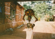 Powiększ zdjęcie Honorin, żona kucharza niesie na plecach synka, a na głowie owoc palmy, z którego wyrabia się olej