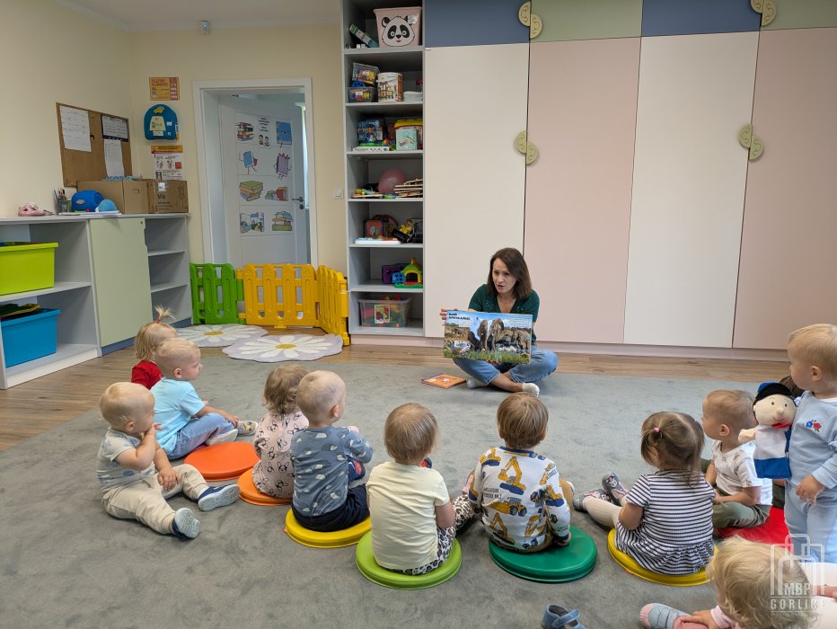 Biblioteka Gorlice, bibliotekarka pokazuje księżkę interaktywną o zwierzętach