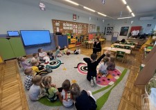 Powiększ zdjęcie Bibliotekarka czyta dzieciom w przedszkolu lekturę 