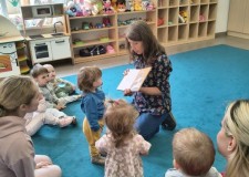 Powiększ zdjęcie Bibliotekarka czyta dzieciom książkę