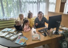 Przejdź do - Bibliotekarka%20prezentuje%20dzieciom%20ladę%20biblioteczną