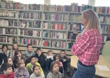 Powiększ zdjęcie Bibliotekarka czyta o przygodach niesfornego ziarenka w bibliotece